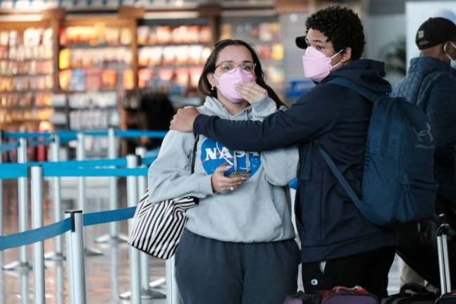 Udhëtarët e veshur me maska ecin brenda aeroportit John F. Kennedy në New York City më 19 Prill 2022.