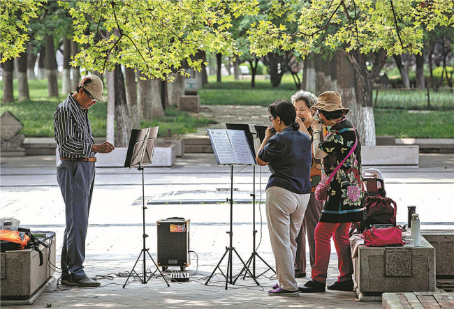 Starší lidé se učí hrát na harmoniku v parku Yongdingmen (Jung-ting-men), dne 13. září 2020. [Fotografie: Zhang Jie (Čang Ťie) / deník China Daily]