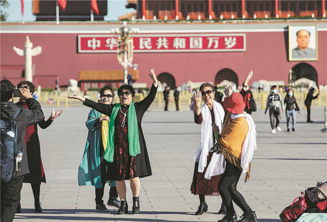 Přátelé se scházejí na náměstí Tian'anmen (Tchien-an-men), zpívají a tancují na melodii klasické písněMiluji pekingský Tian'anmen, 12. října 2020. [Fotografie: Zhang Jie (Čang Ťie) / deník China Daily]