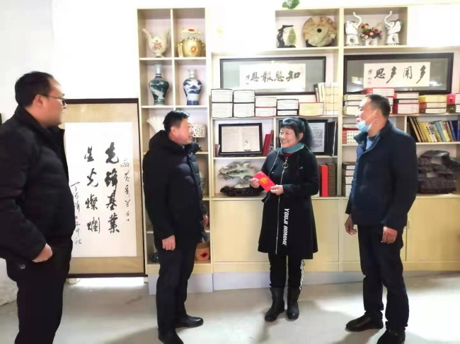 Foto 10: Li Baolin (druhý zleva), předseda Shromáždění lidových zástupců vesnice Guanzhuang, navštěvuje Huang Xiulan (Chuang Siou-lan), „dobrého člověka ve městě Anqing (An-čching)“ a morální model města Qianshan
