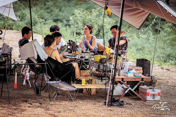 Táborníci relaxují v táboře Sanbin (San-pin) nedaleko od jezera Songlin (Sung-lin) v okresu Anji (An-ťi) v provincii Zhejiang (Če-ťiang). [Fotografii poskytl deník China Daily]