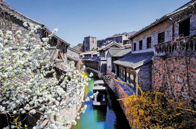 Pekingské vodní městečko v obvodu Miyun je horká turistická atrakce. Nabízí vodní scenerie, část Velké čínské zdi a procházku kameny vydlážděnými ulicemi se šedými a žlutými cihlovými domky podél vodních kanálů. [Fotografie: Yang Feiyue / Deník China Daily]