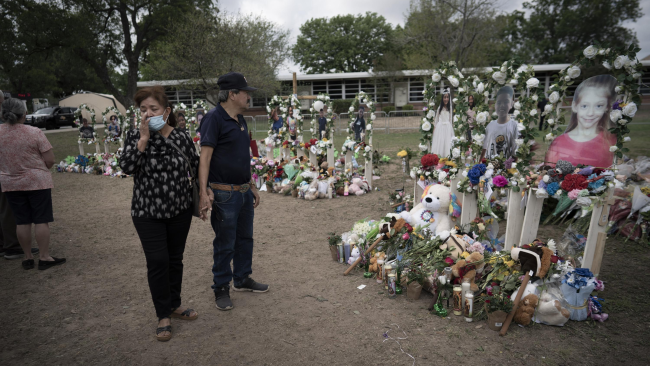 Lidé navštěvují památník před Základní školou Robb v Uvalde v Texasu v pondělí 30. května 2022. / AP