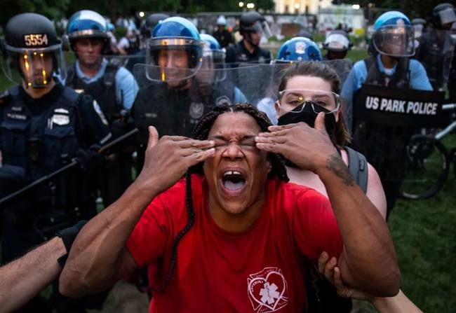 Usona militpolicano ŝprucigis pipran pulvoron sur protestanton en protesto “Nigraj Vivoj Gravas” la 22-an de junio, 2020.<br><br>