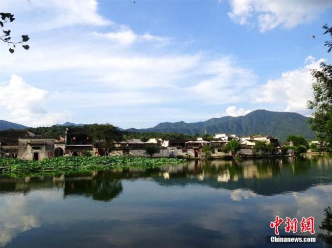 Ένα ποιητικό σκηνικό εμφανίζεται στο χωριό Χονγκτσούν, που φαίνεται να δίνει καθημερινή παράσταση στα μάτια όσων το επισκέπτονται, κοντά στην πόλη Χουανγκσάν της επαρχίας Ανχούι, σε φωτογραφία από τις 8 Αυγούστου 2021. (Φωτογραφία/ China News Service)