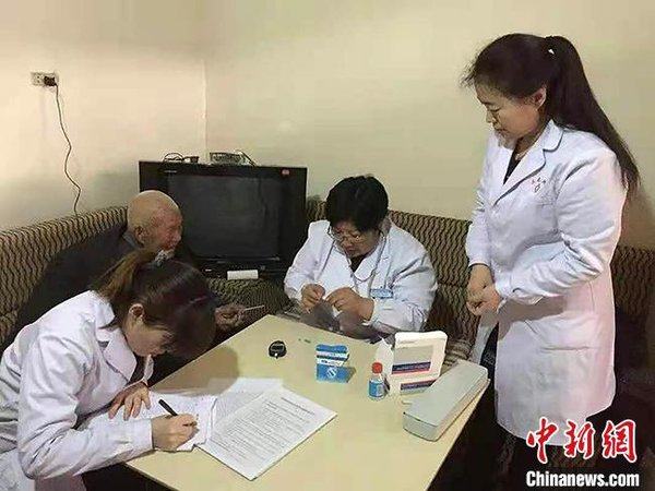 Η Φενγκ Σισιά (2η δεξιά) πραγματοποιεί μια τηλεφωνική παρακολούθηση ασθενούς για να ελέγξει την κατάστασή του.