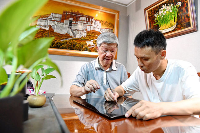 Ο Τζενγκ Σιουτσιέν (αριστερά), που είναι δάσκαλος τεχνών και εκπρόσωπος της τεχνικής «λάκα χωρίς σώμα» στο Φουτζόου, διδάσκει σε έναν μαθητευόμενο τις τεχνικές λακαρίσματος με βελόνες στο Φουτζόου στις 23 Ιουλίου. [Φωτογραφία/Xinhua]