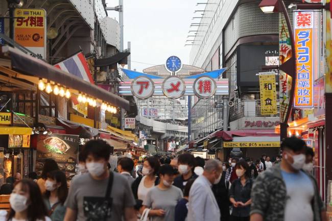 Πολίτες με μάσκες περπατούν σε δρόμο στο Ουένο του Τόκυο, στις 20 Μαΐου 2020.