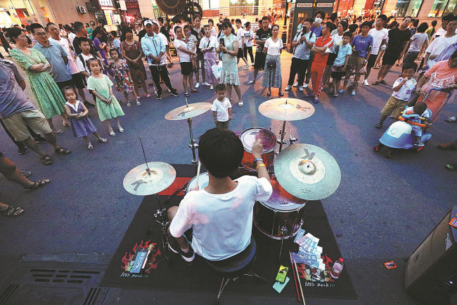 Επισκέπτες παρακολουθούν μια μουσική παράσταση στην Οδό Γουανσένγκ στα Hengdian World Studios στις 17 Ιουλίου. 