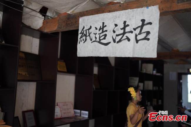 Η Γιου Καν’εν παρουσιάζει τις αρχαίες δεξιότητες δημιουργίας χαρτιού στους τουρίστες στην κομητεία Μενγκχάι στον αυτόνομο νομό Ντάι της περιοχής Σισουανγκμπανά στην επαρχία Γιουνάν της νοτιοδυτικής Κίνας, την 1η Σεπτεμβρίου 2021. (Φωτογραφία: China News Υπηρεσία/Kang Ping)