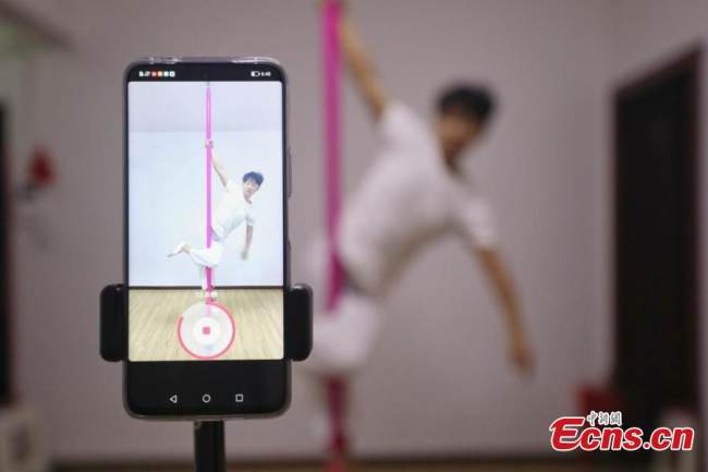 Ο Τζανγκ Σιντά βγάζει βίντεο με το τηλέφωνό του ενώ χορεύει, στο Τσενγκντού, στην επαρχία Σιτσουάν της νοτιοδυτικής Κίνας, στις 13 Σεπτεμβρίου 2021. (Φωτογραφία: China News Service)