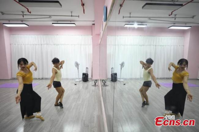 Ο Τζανγκ Σιντά εξασκεί χορευτικές κινήσεις υπό την καθοδήγηση της δασκάλας του, σε ένα στούντιο χορού στο Τσενγκντού, στην επαρχία Σιτσουάν της νοτιοδυτικής Κίνας, στις 13 Σεπτεμβρίου 2021. (Φωτογραφία: China News Service)