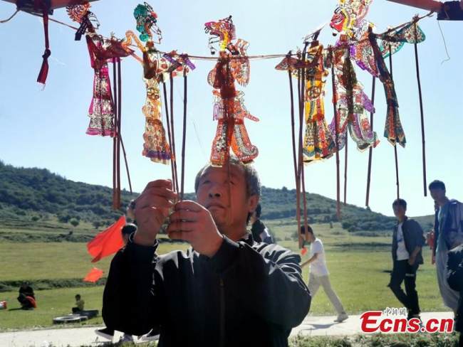 Χωρικοί παίζουν την παραδοσιακή τέχνη του θεάτρου των σκιών στην κομητεία Τσινγκσούι στις 21 Σεπτεμβρίου 2021. 