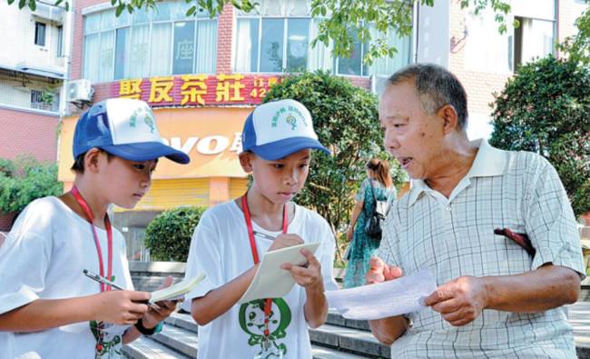 Μαθητές σε μια καλοκαιρινή κατασκήνωση παίρνουν συνεντεύξεις από τους κατοίκους για την προστασία του περιβάλλοντος (Η φωτογραφία παρέχεται στην China Daily)