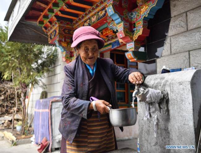 Η Ντάουα παίρνει νερό από την βρύση στην αυλή της στην Κοινότητα Κεσούμ της πόλης Σανάν, στην Αυτόνομη Περιφέρεια του Θιβέτ της νοτιοδυτικής Κίνας, 15 Μαρτίου 2021. [Xinhua/Jigme Dorje]