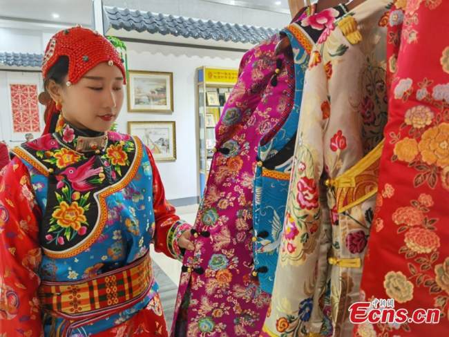 Μια Θιβετιανή τεχνίτρια παρουσιάζει παραδοσιακές φορεσιές σε μια τοπική έκθεση στο Λαντζόου της επαρχίας Γκανσού στις 17 Οκτωβρίου 2021. (φωτογραφία / China News Service)