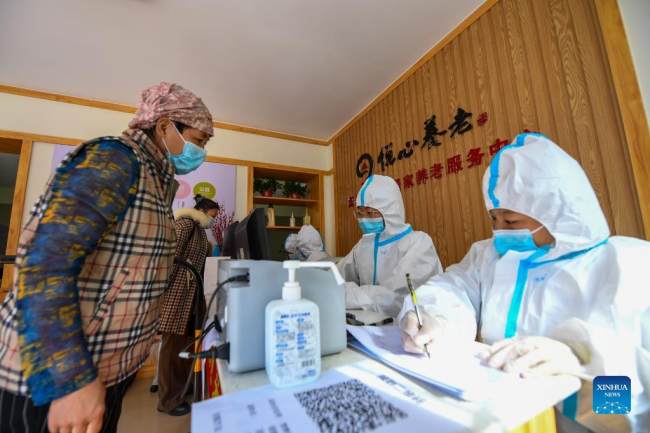 Ιατρικό προσωπικό καταγράφει προσωπικά στοιχεία σε ένα προσωρινό σημείο για τεστ νουκλεϊκού οξέος (核酸检测: hésuān jiǎncè) νέου κορονοϊού (新冠肺炎: Xīnguān fèiyán), στο Χοχότ, αυτόνομη περιοχή της Εσωτερικής Μογγολίας στην βόρεια Κίνα, 24 Οκτωβρίου 2021.