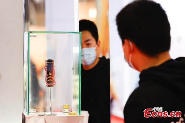 Ένας επισκέπτης κοιτάζει το νέο κινητό τηλέφωνο (手机 : Shǒujī) 4G "Cobra" Signature V με τιμή 2,89 εκατομμύρια γιουάν στο περίπτερο VERTU στον τομέα Καταναλωτικών Αγαθών της 4ης CIIE, στο Εθνικό Εκθεσιακό και Συνεδριακό Κέντρο στην Σαγκάη (上海: Shànghǎi) στις 8 Νοεμβρίου 2021. (Φωτογραφία: China News Service)