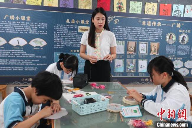 Η Λιανγκ Σιαομάν διδάσκει τεχνικές κεντήματος στους μαθητές σε ένα σχολείο στο Γκουανγκτζόου. (Chinanes.com)