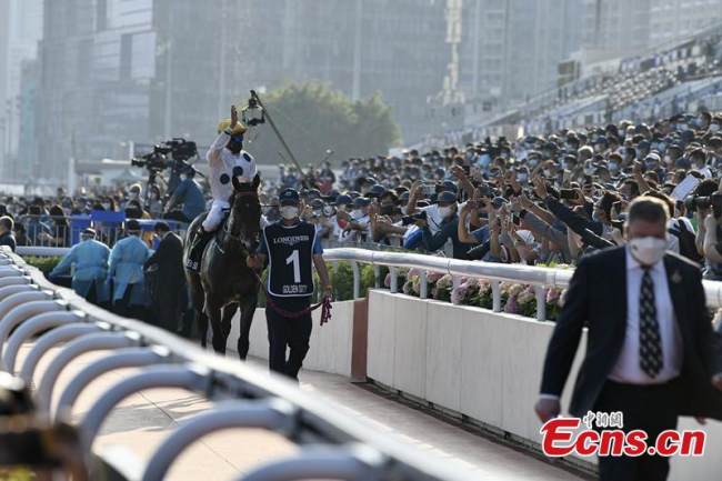 Πρωταθλητής αναβάτης πάνω στο άλογό του χαιρετά τους θεατές στον ιππόδρομο Sha Tin στην Ειδική Διοικητική Περιοχή του Χονγκ Κονγκ, 12 Δεκεμβρίου 2021. (φωτογραφία / China News Service)