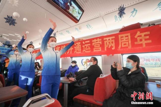 Προσωπικό του σιδηροδρόμου χορεύει για τους Χειμερινούς Ολυμπιακούς Αγώνες για τους ταξιδιώτες στο τρένο υψηλής ταχύτητας G8811 με προορισμό τον σταθμό Taizicheng, 30 Δεκεμβρίου 2021. (φωτογραφία/China News Service) 
