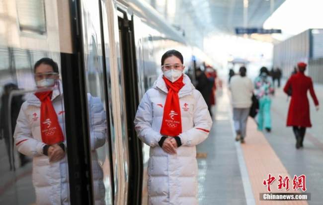 Το προσωπικό του τρένου υψηλής ταχύτητας G8811 υποδέχεται τους επιβάτες στο Βόρειο Σιδηροδρομικό Σταθμό του Πεκίνου στο Πεκίνο, 30 Δεκεμβρίου 2021. (φωτογραφία/China News Service)