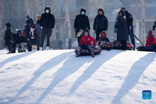 Κόσμος παίζει στον πάγο σε ένα πάρκο στο Χαρμπίν, στην επαρχία Χεϊλονγκτζιάνγκ της βορειοανατολικής Κίνας, 3 Ιανουαρίου 2022. (Xinhua/Wang Jianwei)