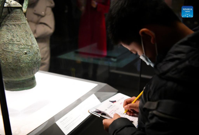 Ένας μαθητής κρατά σημειώσεις ενώ επισκέπτεται το Μουσείο Χενάν την τρίτη ημέρα των διακοπών της Πρωτοχρονιάς στο Τζενγκτζόου, στην επαρχία Χενάν της κεντρικής Κίνας, 3 Ιανουαρίου 2022. (Xinhua/Hao Yuan)