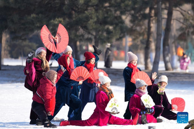 Οι άνθρωποι ποζάρουν για μια ομαδική φωτογραφία σε ένα χιονισμένο πάρκο στο Χαρμπίν, στην επαρχία Χεϊλοτζιάνγκ της βορειοανατολικής Κίνας, 3 Ιανουαρίου 2022. (Xinhua/Wang Jianwei)