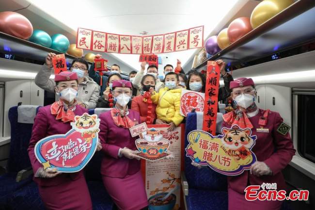 Επιβάτες (乘客 Chéngkè) και συνοδοί τρένων (乘务员Chéngwùyuán) Fuxing EMU (C5980) βγάζουν μια ομαδική φωτογραφία, στο Μπιτζιέ, στις 9 Ιανουαρίου 2022. (Φωτογραφία: China News Service)