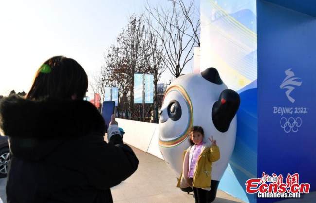 Μια μητέρα φωτογραφίζει την κόρη της στη Χειμερινή Ολυμπιακή Πολιτιστική Πλατεία Σιονγκ’άν, 11 Ιανουαρίου 2022. (Φωτογραφία: China News Service)