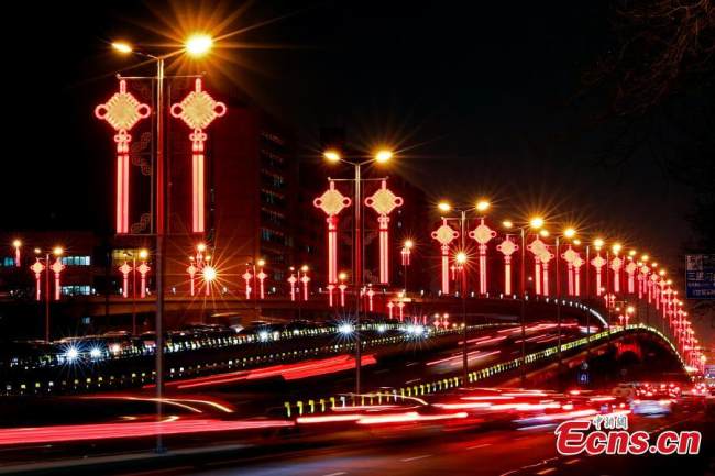 Διακοσμήσεις σε σχήμα κινεζικού κόμπου φωτίζουν τη λεωφόρο Τσανγκ’αν στο Πεκίνο, στις 20 Ιανουαρίου 2022. (Φωτογραφία: China News Service/Sheng Jiapeng)