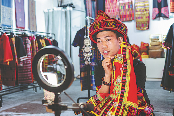 Ο Χουάνγκ κατά τη διάρκεια μιας ζωντανής μετάδοσης πώλησης των ρούχων του με μπροκάρ Λι. (φωτογραφία/XINHUA)