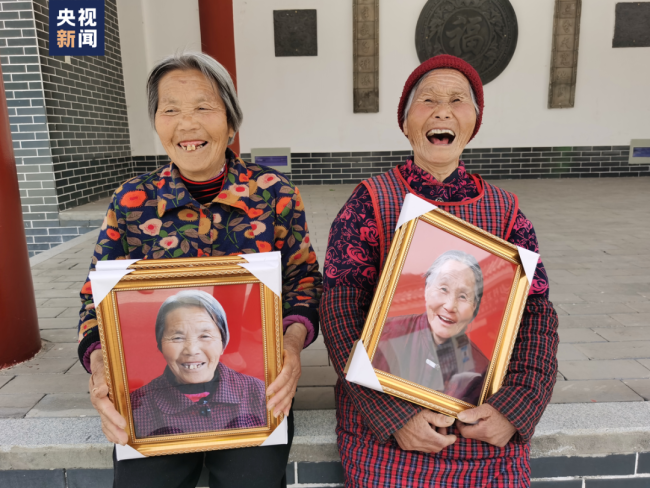 Κάτοικοι του χωριού με ένα πλατύ χαμόγελο στα πρόσωπά τους αφότου έλαβαν τις φωτογραφίες τους. (Φωτογραφία/CCTV)