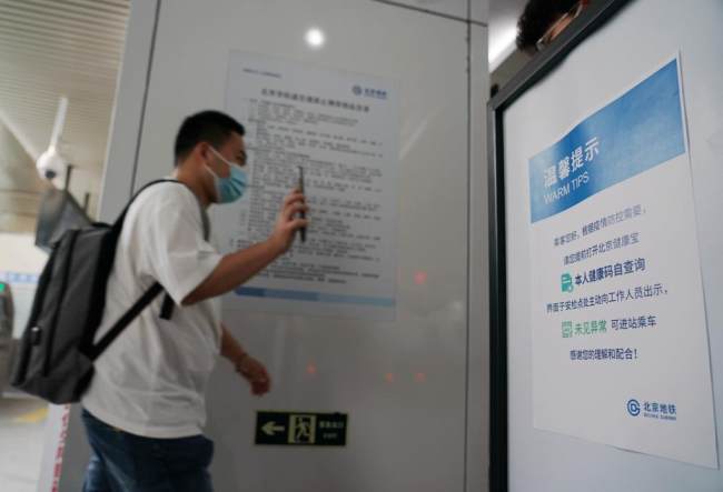 Ένας επιβάτης δείχνει τον κωδικό QR υγείας πριν μπει σε σταθμό του μετρό στο Πεκίνο, πρωτεύουσα της Κίνας, 17 Μαΐου 2022.