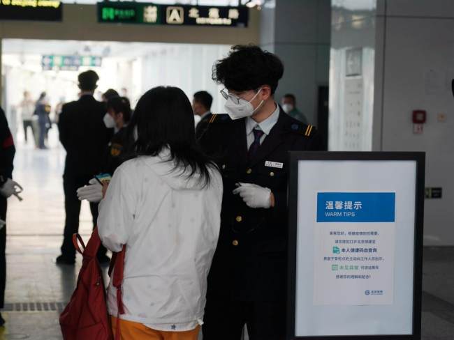 Ένα μέλος του προσωπικού ελέγχει τον κωδικό QR υγείας ενός επιβάτη σε σταθμό του μετρό στο Πεκίνο, πρωτεύουσα της Κίνας, 17 Μαΐου 2022.