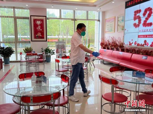 Καθημερινή απολύμανση σε ένα κέντρο εγγραφής γάμων στην περιοχή Τσαομίνγκ, στη Σαγκάη της ανατολικής Κίνας, 20 Μαΐου 2022. (Φωτογραφία: China News Service)