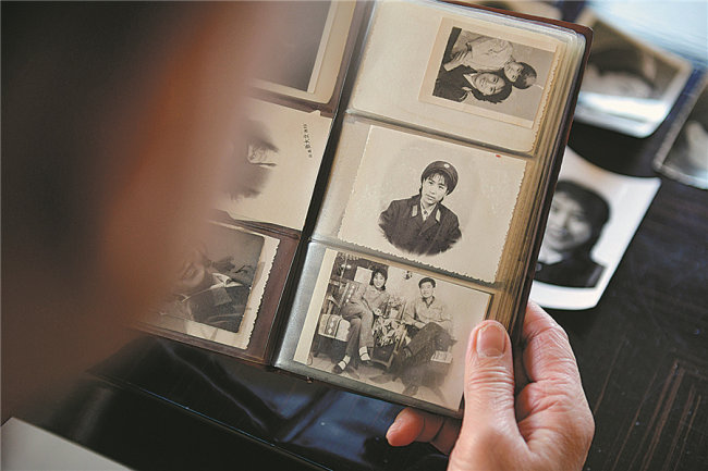 Η Γκουό Λιρόνγκ, κοιτάζει φωτογραφίες της νιότης της. [Φωτογραφία/China Daily]