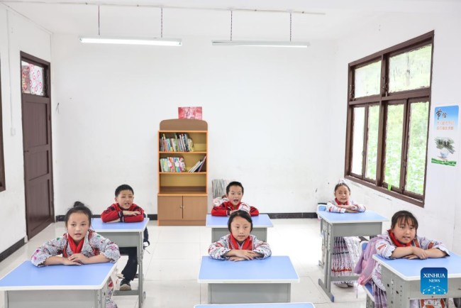 Η Γιανγκ Γιαμένγκ (1η αριστερά) παρακολουθεί μάθημα με τους συμμαθητές της σε ένα δημοτικό σχολείο στο χωριό Χουαγού της πόλης Σινρέν Μιάο, στην πόλη Τσιανσί της επαρχίας Γκουιτζόου της νοτιοδυτικής Κίνας, 1 Ιουνίου 2022. 