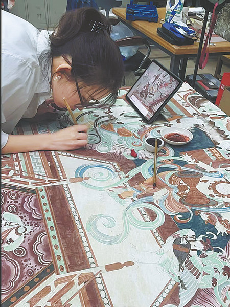 Αφού σκάψει το χώμα στην όχθη της λίμνης, η Τσιν το συνθλίβει σε κομμάτια, το κοσκινίζει και φτιάχνει ένα σχέδιο με αυτό. Στη συνέχεια ζωγραφίζει πάνω του για να ξαναδημιουργήσει τοιχογραφίες από το αρχαίο παρελθόν, όπως αυτές στις σπηλιές Μογκάο στο Ντουνχουάνγκ στην επαρχία Γκανσού της βορειοδυτικής Κίνας. (φωτογραφία/CHINA DAILY)