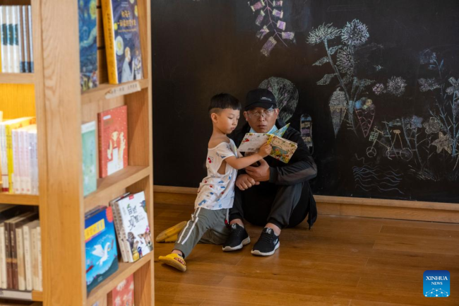 Τουρίστες διαβάζουν σε ένα βιβλιοπωλείο στο χωριό Ντανανπό της κομητείας Χιουγού στην πόλη Τζιαοζουό, στην επαρχία Χενάν της κεντρικής Κίνας 31 Ιουλίου 2022.